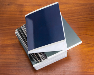 Stack of the different exercise books on wooden table