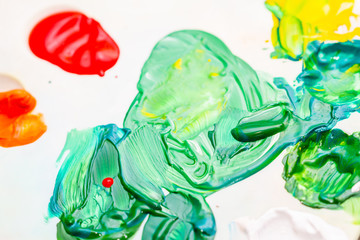 Mixed multicolored paints on the palette. Closeup, selective focus
