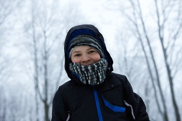 Fototapeta na wymiar Little boy in winter forest