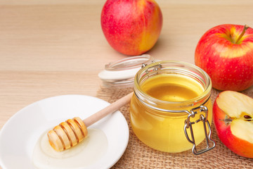 Jewish holiday Rosh Hashanah background with honey and apples on wooden table.