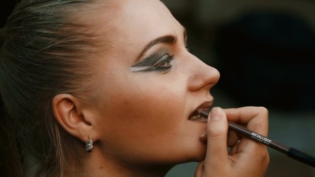 Make-up artist makes make-up young woman lips.Make-up artist doing make-up lip pencil to stroke the lips.Makeup. Cosmetic.