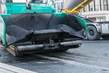 Nahaufnahme eines Asphaltfertiger auf einer Baustelle bei der Erneuerung der Fahrbahndecke, Deutschland