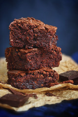 Three pieces of fudge brownies on blue background