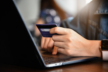 Online payment,woman's hands holding credit card and using laptop computer for online shopping. Cyber Monday Concept