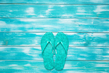 flip flops on blue wooden floor.