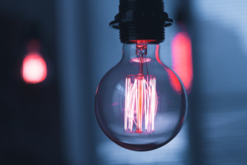 A classic Edison light bulb on dark background with space for text