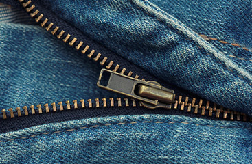 Metal zipper on blue shabby jeans