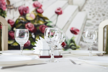 Glasses and glasses for wine on a table with a white tablecloth in a restaurant
