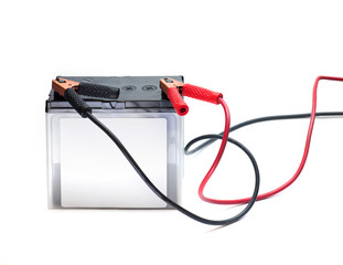 A Car battery with red and black battery Jumper or booster cables with copper clamps attached to the terminals. Automotive battery isolated on white.