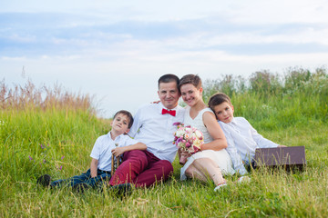 Romantic family in the field in the summer outdoors