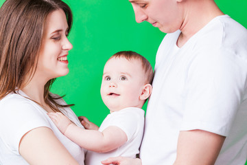 Young family portrait isolated on a green background