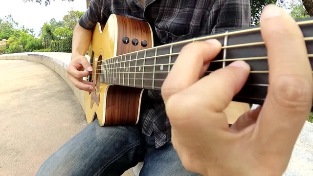 Playing acoustic guitar in the park