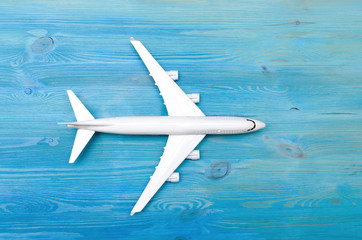 Toy airplane isolated on blue wooden table surface background. Air transportation concept.