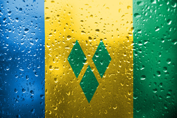 Texture of  Saint Vincent and the Grenadines  flag on the glass with drops of rain.