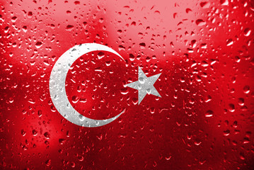 Texture of Turkey flag on the glass with drops of rain.