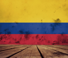 The floor of planks and plastered wall with a painted Colombia   flag.