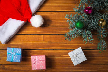 Christmas decorations. Holiday composition with fir branch, toy balls, santa hat, gift boxies. Top view.