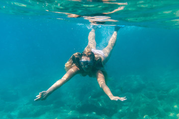 Young woman snorkeling underwater in the tropical sea