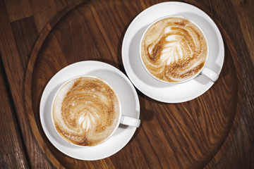 Two cappuccino coffee on wooden table