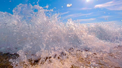 The wave runs on the beach in summer on a Sunny day