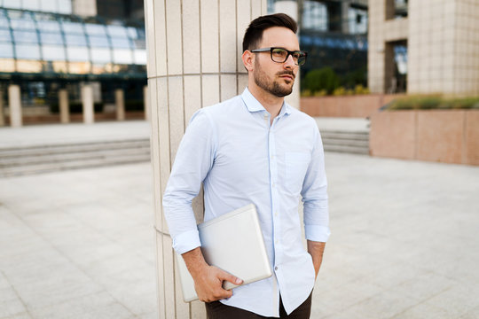 Happy and confident businessman using tablet