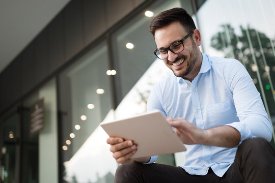 Portrait of businessman in glasses holding tablet