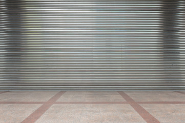 A closeup shot of automatic metal roller door used in factory, storage, garage, and industrial warehouse. The corrugated and foldable metal sheet offer space saving and provide urban and rustic feel