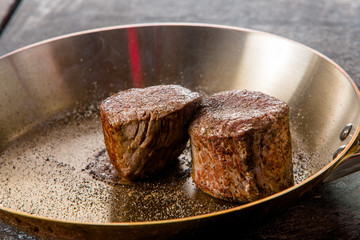 beef steaks are fried in a frying pan in a restaurant
