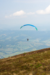 Paraglider takes off from the mountainside in the Carpathian Mountains. Paragliding in the mountains in the summer.