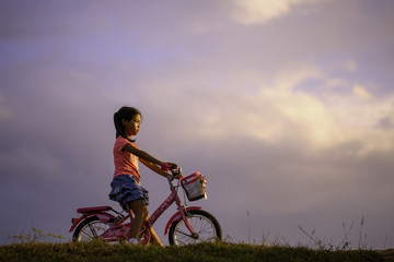 Fototapeta premium A female schoolchild fun with bicycle in the park.