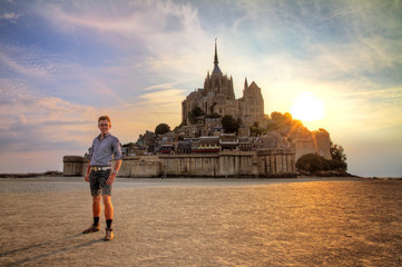 Divine tourist in front of historic landmark Le Mont Saint-Michel in Normandy, France, a famous...