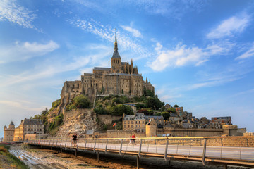 Beautiful view of historic landmark Le Mont Saint-Michel in Normandy, France, a famous UNESCO world heritage site and tourist attraction, in summer - obrazy, fototapety, plakaty