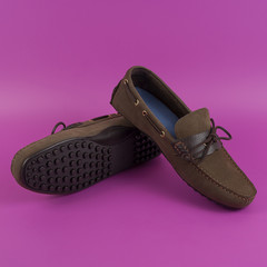 Men's brown moccasins, loafers isolated on pink background.