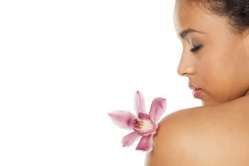 profile of young beautiful dark-skinned woman with orchid on a white background © vladimirfloyd
