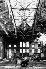 A white drum set stands in an abandoned hangar, an abandoned red brick plant. devastation, post apocalypse, urbex