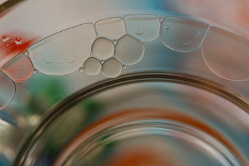Close up oil bubbles floating on water surface  with color background