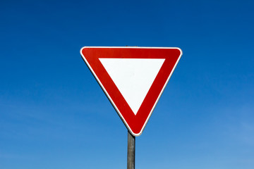 Yield give way sign on a blue sky background