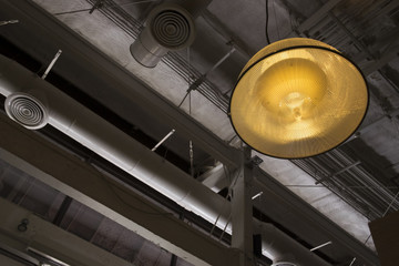 Big light bulb hanging from ceiling loft style. Background and texture of lamp and ceiling decorations in loft style.