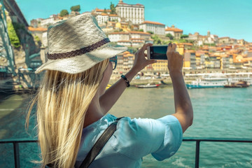 Obraz na płótnie Canvas traveler blonde woman - tourist shot on her smartphone camera old port city