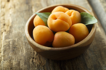 Fresh apricots in the wooden bowl