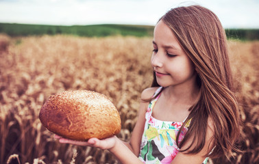 Childhood time. Happy little girl in the wheat field. Childhood, food, lifestyle concept