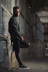Fototapeta na wymiar Fashionable stylish african american man wear torn jeans in urban territory