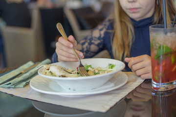 girl eating salad in cafe