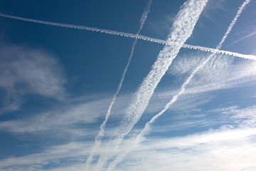 A blue sky with white clouds and an airplane leaving a thin white trail. Can be the background.