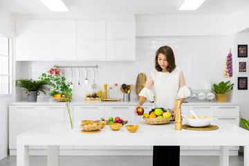 Beautiful Asian woman showing her new kitchen decoration and play with fake fruits and vegetables. Concept to modern housewife work.