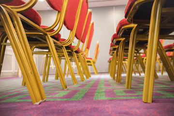 Row of red soft chairs in a conference room with a carpet