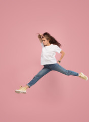 What is there interesting in the distance. seeking pretty happy young woman jumping and grabbing against pink studio background. Runnin girl in motion or movement. Human emotions and facial