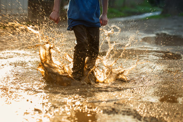 kid in puddle, splashing in puddle
