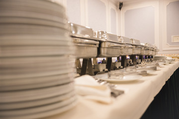 Ceramic white plates stand on top of each other on a table on the trays background