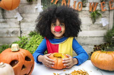 Young girl enjoy carving her Halloween pumpkin